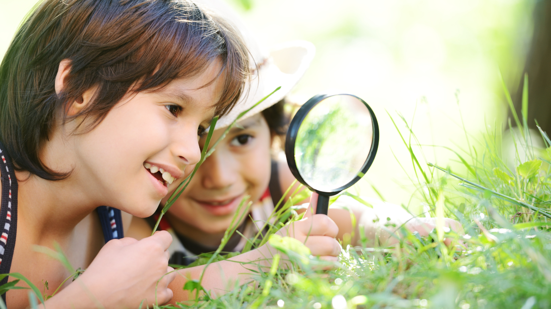 Young girl holding a magnifying glass.