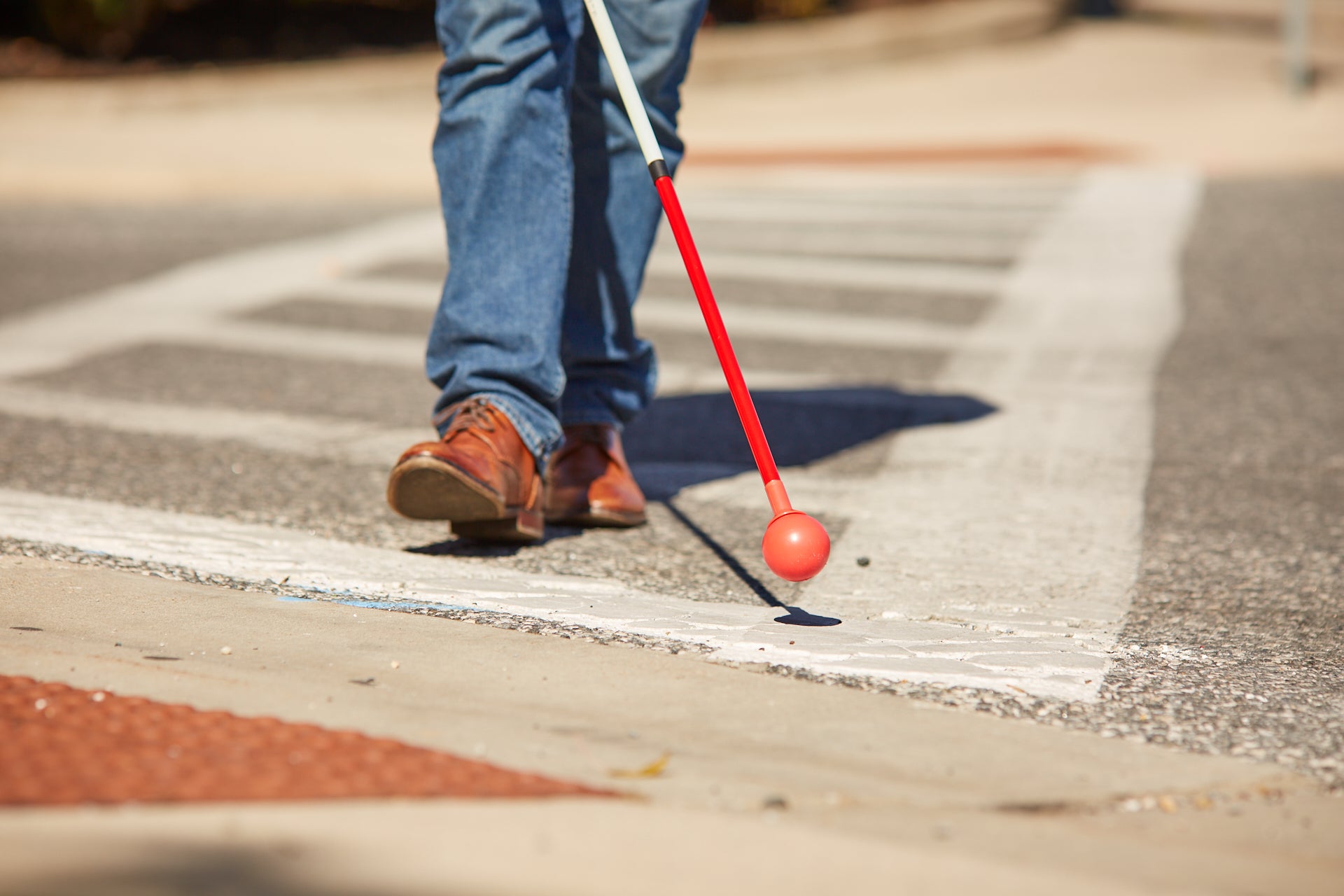 Person using All Terrain Cane on rough ground.