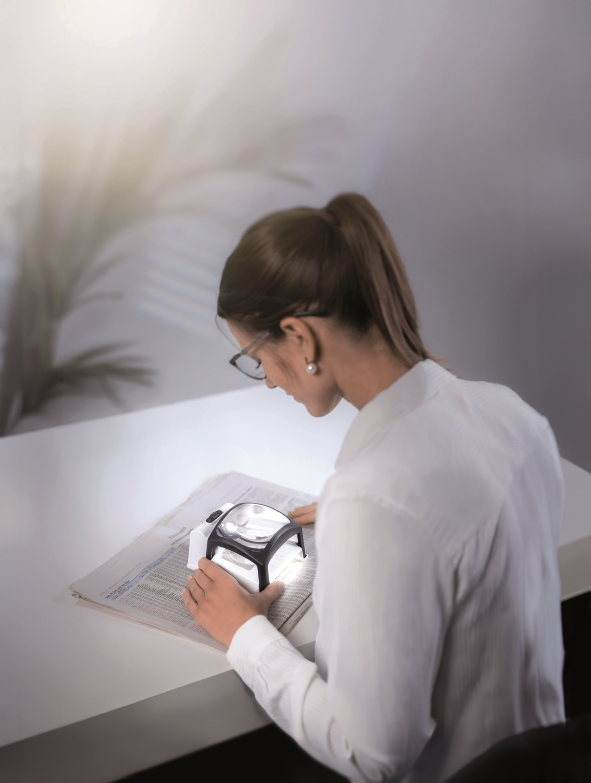 Woman using the TWIN-Lux LED 3.5x stand magnifier.