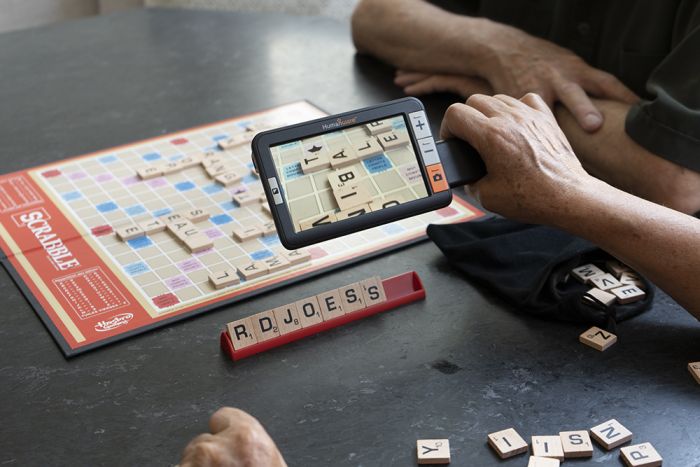 Person using the explore5 while playing Scrabble.