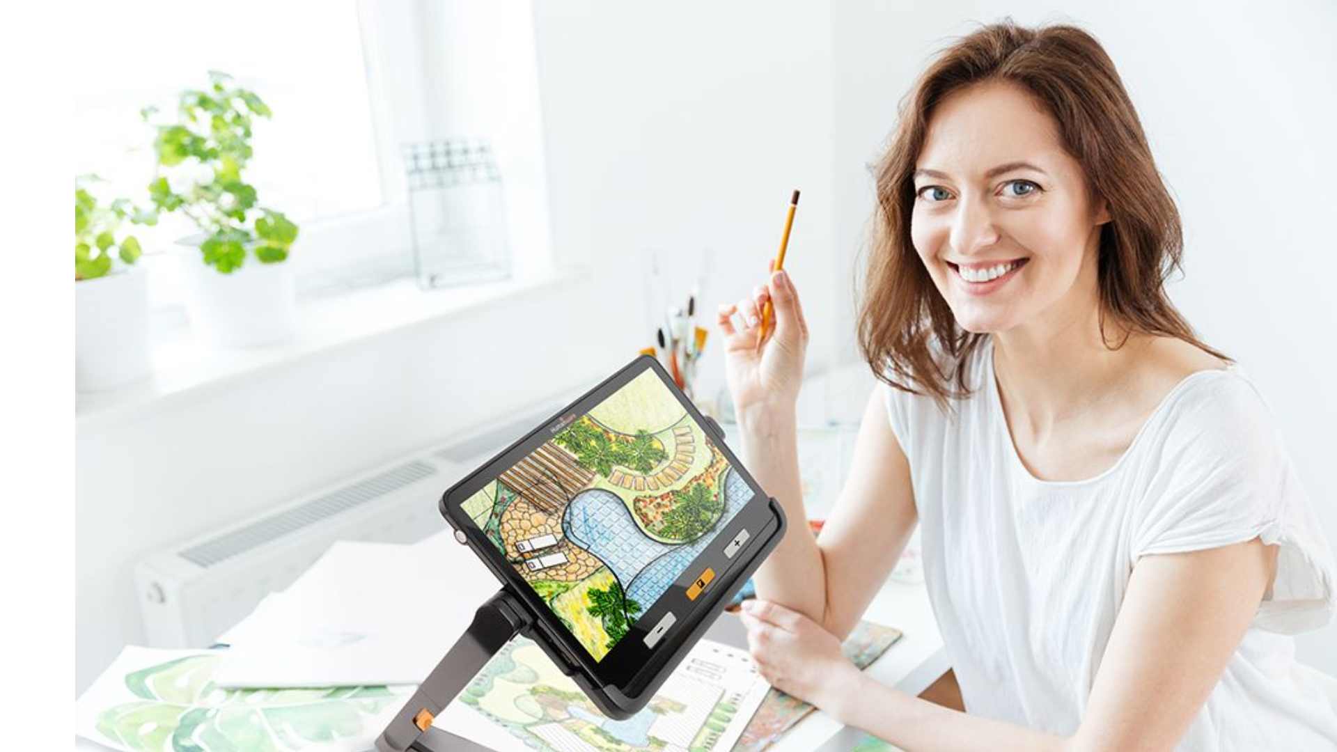 Smiling woman at a desk using a video magnifier.