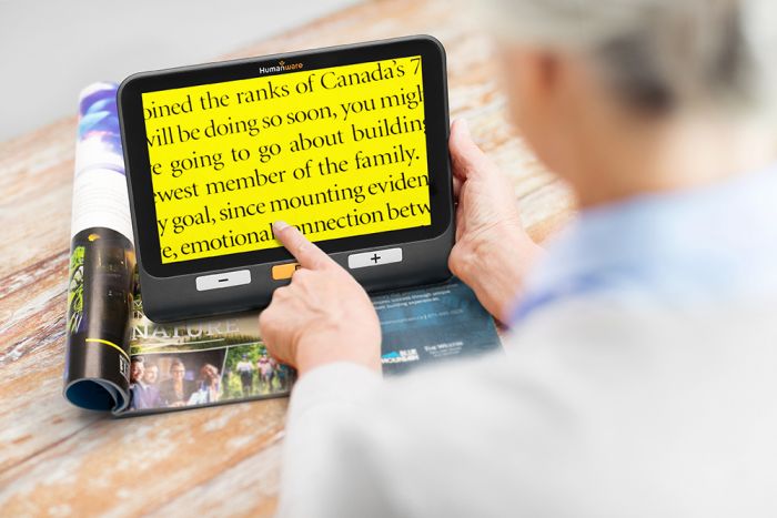 Person reading a magazine using  the explorē 8.