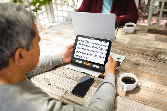 Man reading a magazine using the explorē 8.