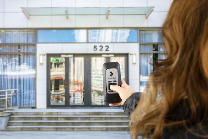 Person standing in front of a building using the StellarTrek.