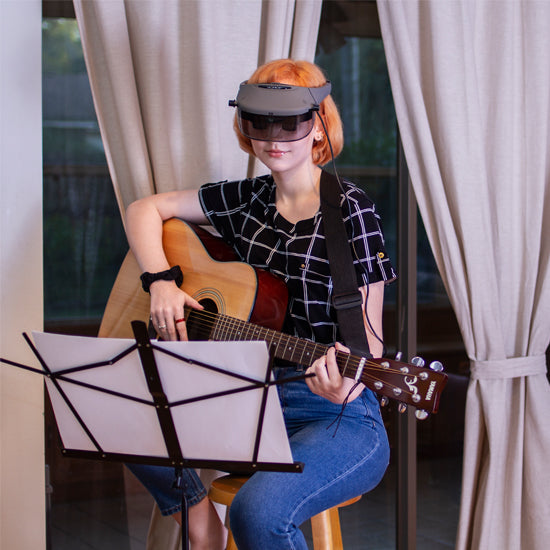Image of a musician using Acesight AR glasses to read sheet musit.