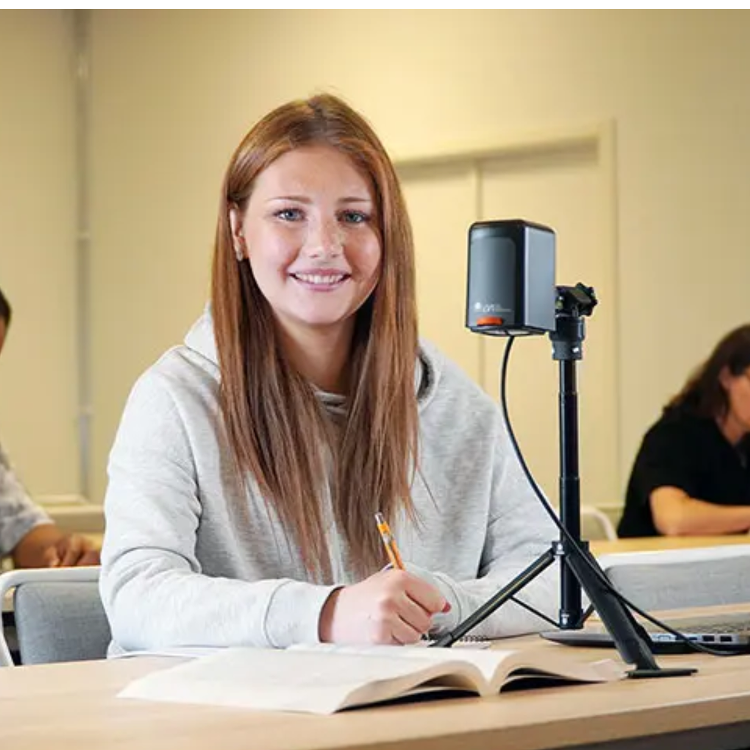Young woman smiling next to MagniLink camera.
