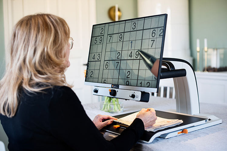 Woman magnifying text on a MagniLink Vision.