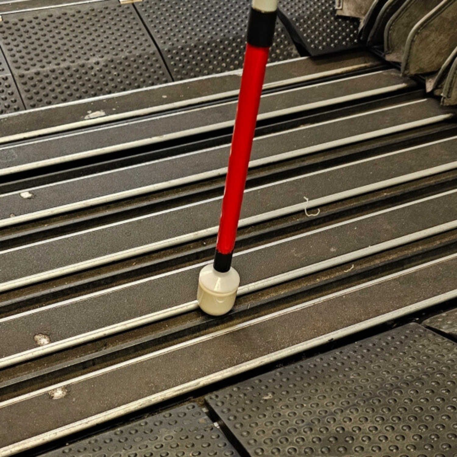 White cane tip on currogated textured ground.