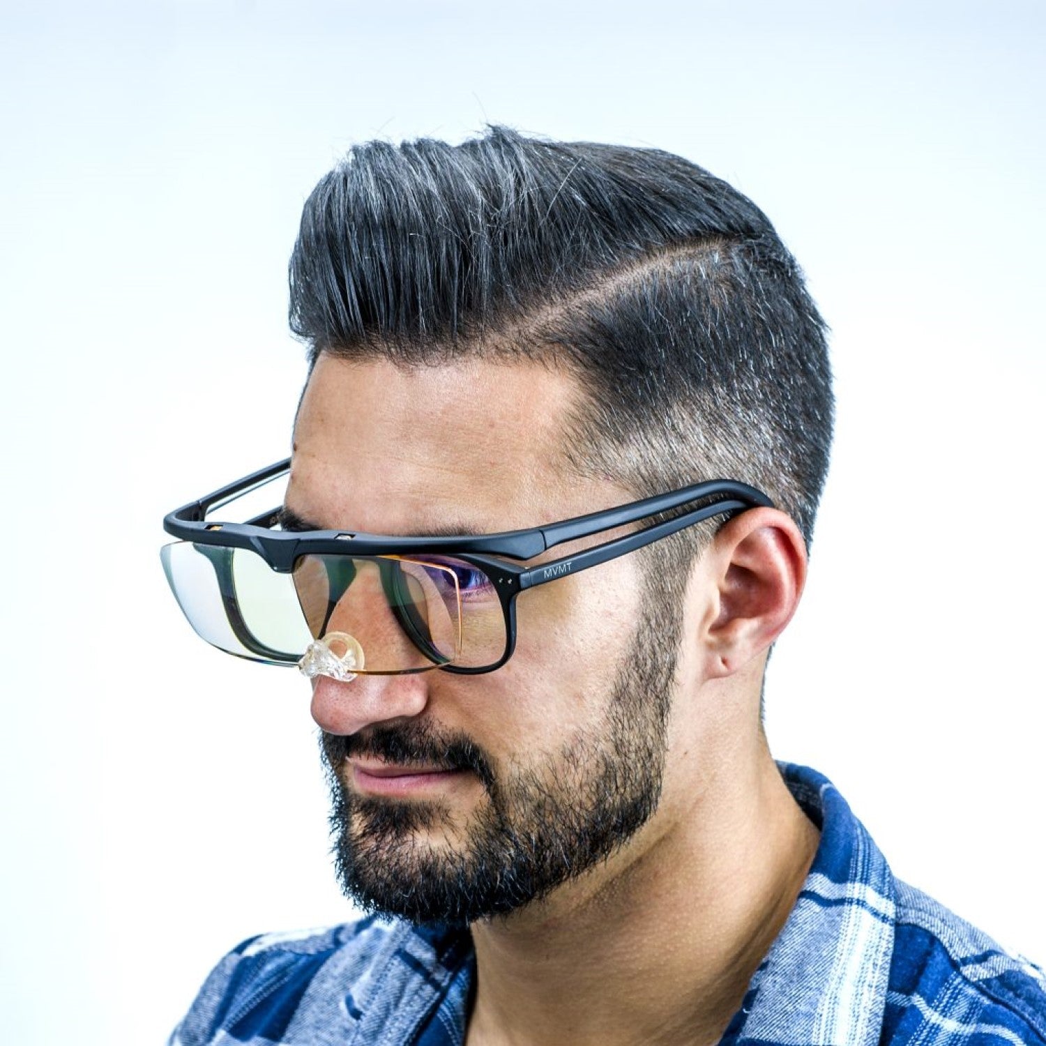 Image of the glasses while worn on a model's face with additional glasses underneath.